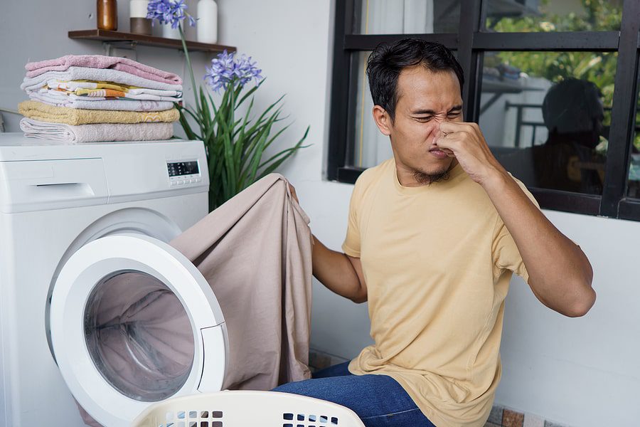 Man smelling washer machine