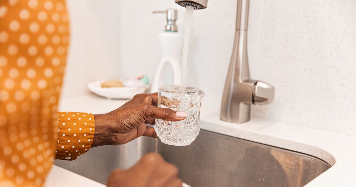 Person getting a glass of tap water