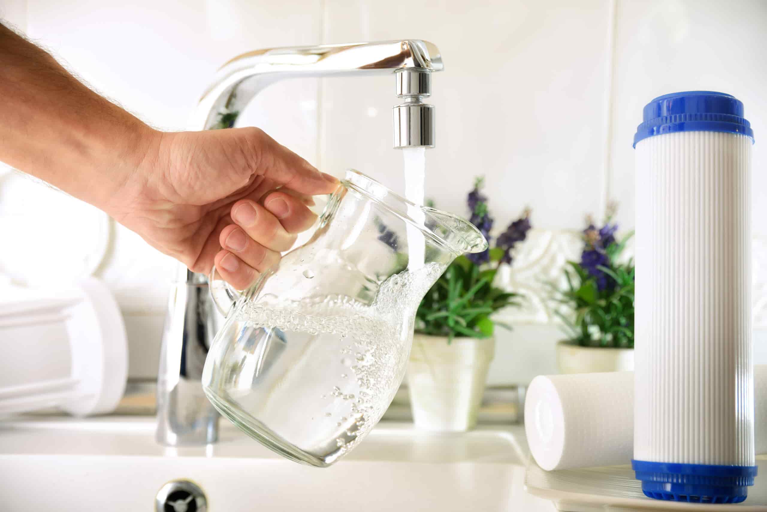 Hand filling jug from a tap with filtered water