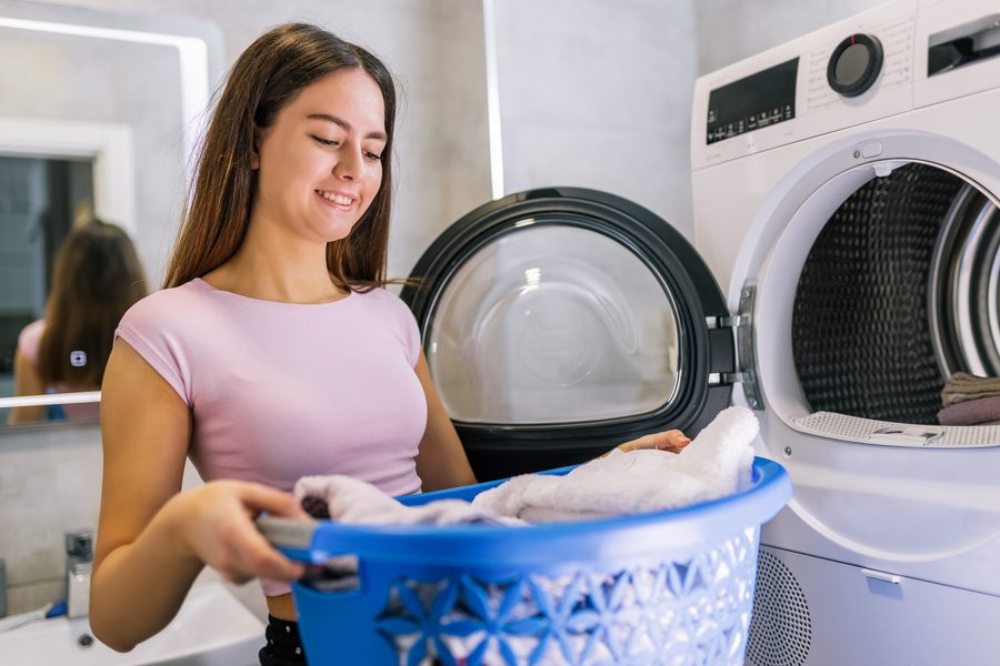 Girl Taking Clean Laundry Out of Dryer