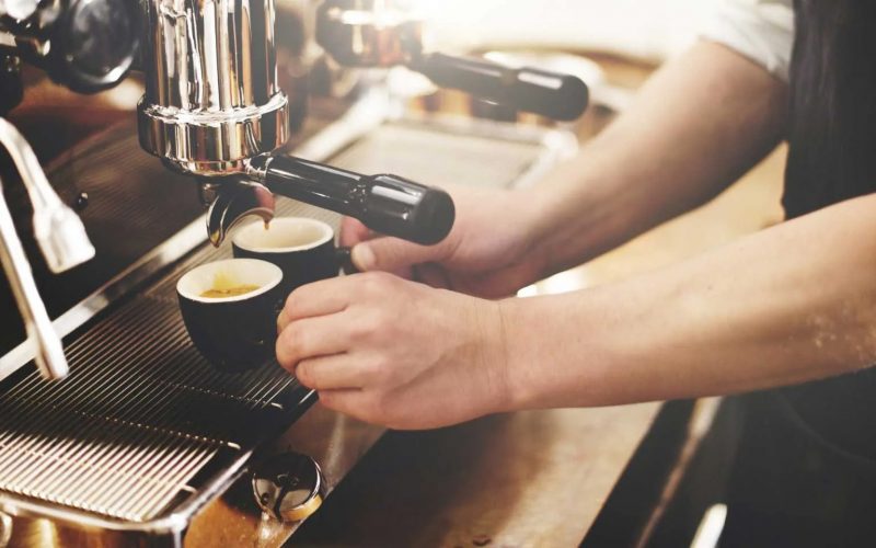 A man taking coffee from a coffee tap